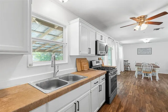 a kitchen that has a sink cabinets counter space and appliances