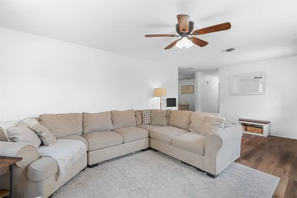 a living room with furniture and a ceiling fan
