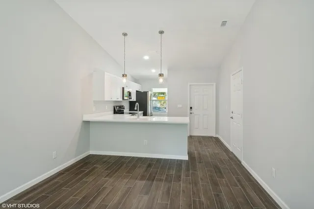 a view of a kitchen with wooden floor and a sink