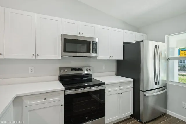 a kitchen with white cabinets and stainless steel appliances