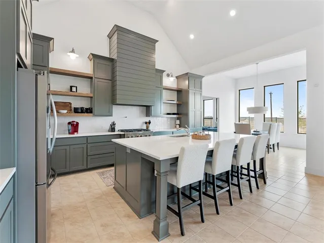 a kitchen with a table chairs refrigerator and cabinets
