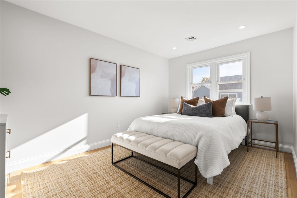 713-715 East 7th Street, Unit 715 Boston, MA 02127 - Photo 11 of 25 a bedroom with a bed lamp and a window