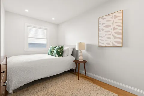 a bed sitting in a bedroom next to a window