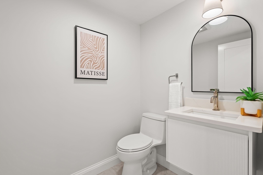 713-715 East 7th Street, Unit 715 Boston, MA 02127 - Photo 10 of 25 a bathroom with a toilet sink and mirror
