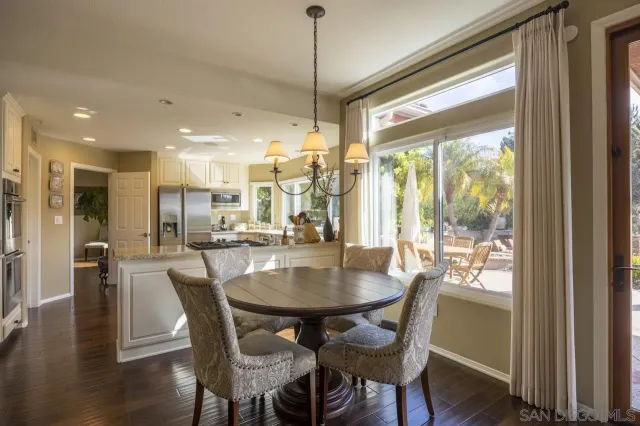a dining room with furniture a chandelier and wooden floor