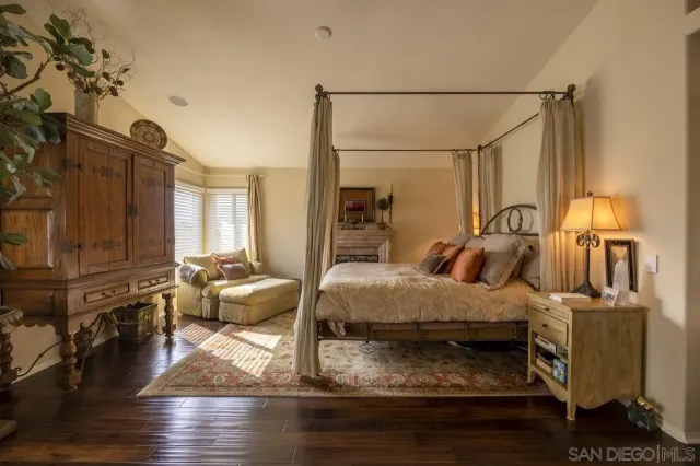 a spacious bedroom with a bed and wooden floor