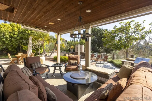 a view of a patio with couches and table and chairs and potted plants