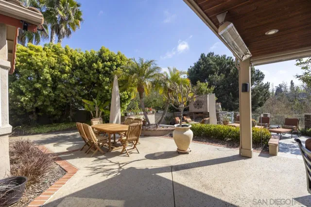 a view of a patio with table and chairs potted plants with wooden floor and fence