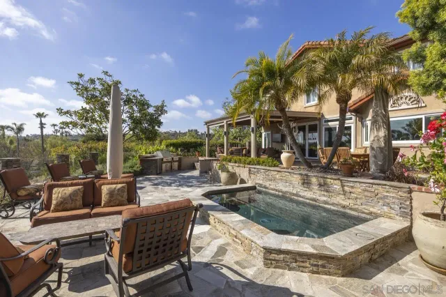 a view of a house with pool and sitting area