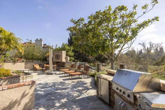 a view of a white house with a swimming pool and lawn chairs