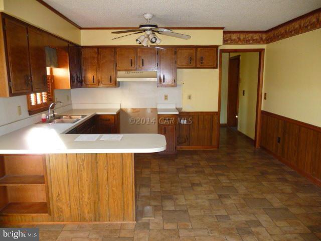 6485 Bent Pine Road Willards, MD 21874 - Photo 7 of 15 a kitchen with kitchen island a sink a counter space and cabinets