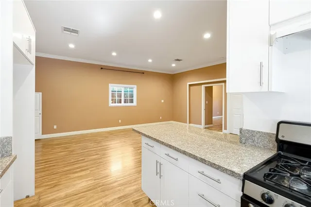 a kitchen with kitchen island a stove and a wooden floor