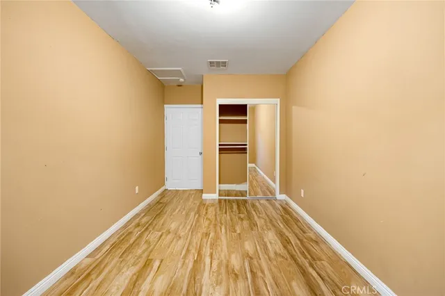 a view of a room with wooden floor and a ceiling fan