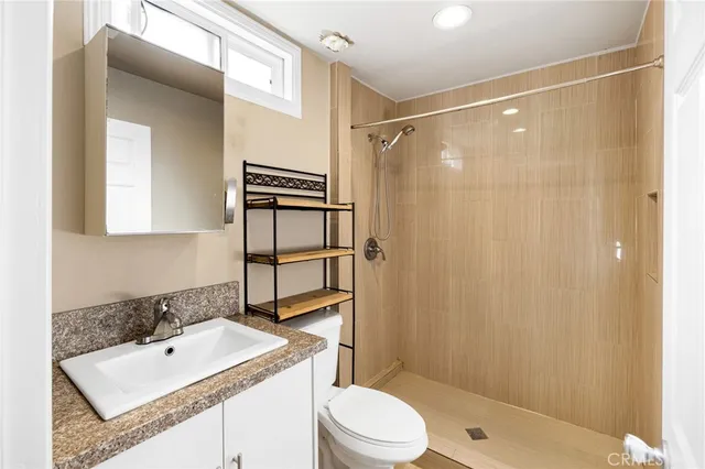 a bathroom with a sink a toilet and shower