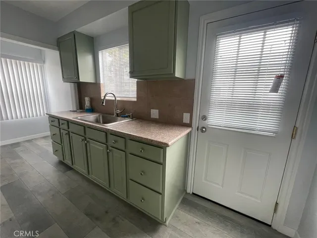 a kitchen with stainless steel appliances granite countertop a sink and a window