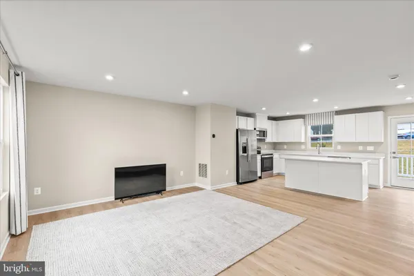 a view of kitchen with kitchen island sink refrigerator and white cabinets