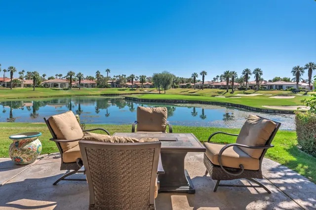 a patio with water view fountain and a big yard