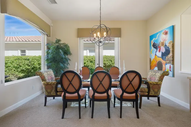 a view of a dining room with furniture a chandelier and wooden floor