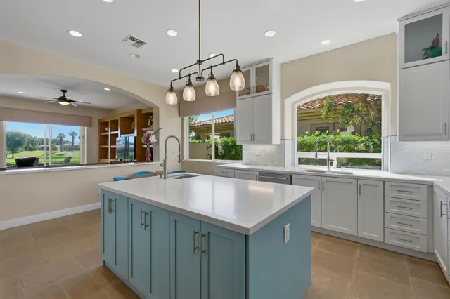 a kitchen with kitchen island a large island in it