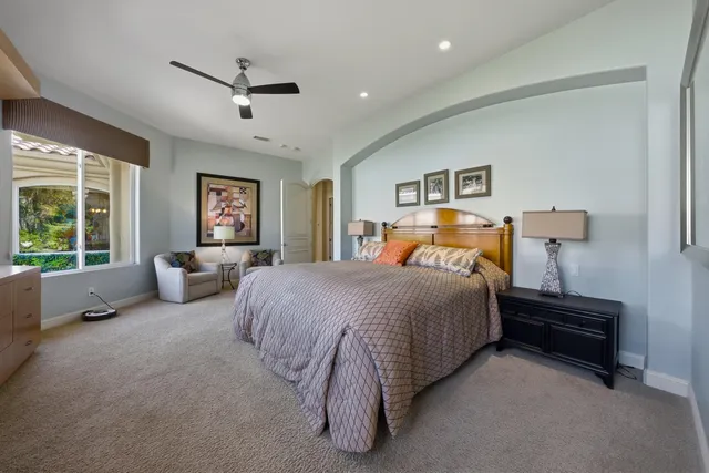 a spacious bedroom with a bed and a large window