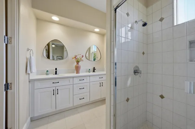 a bathroom with double vanity sink and a mirror