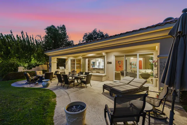 a view of a house with backyard sitting area and garden