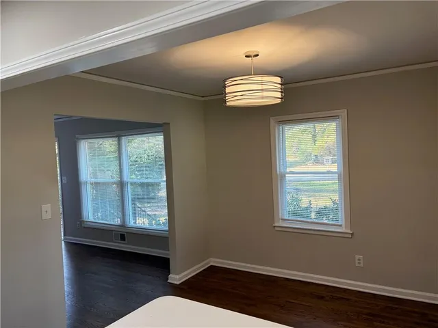 a view of empty room with wooden floor and window
