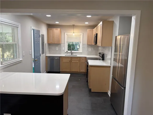 a kitchen with refrigerator and cabinets