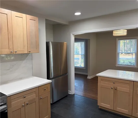 a kitchen with a refrigerator sink and cabinets