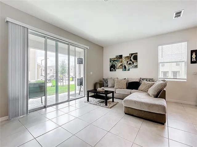 a living room with furniture and large windows