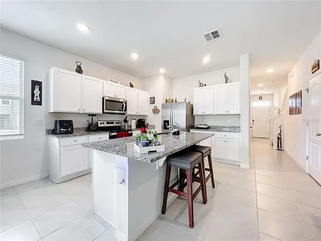 a kitchen with cabinets and chairs