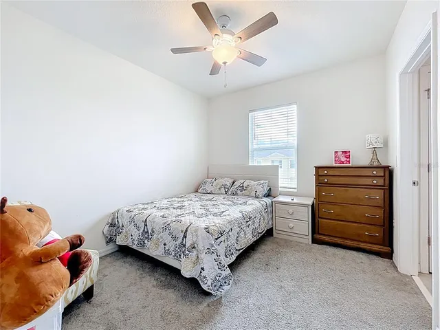 a bedroom with a bed and a chandelier fan