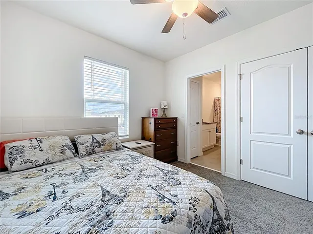 a bedroom with a large bed and a chandelier