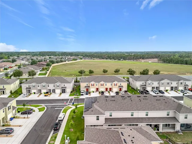 an aerial view of ocean and residential houses with outdoor space