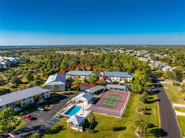 an aerial view of a city with lots of residential buildings ocean and mountain view in back