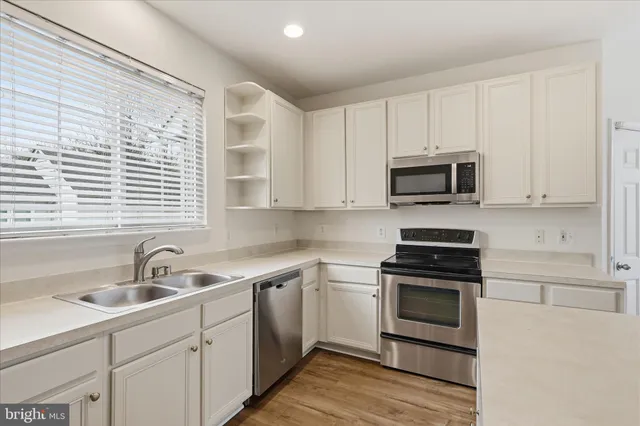 a kitchen with sink a microwave and cabinets