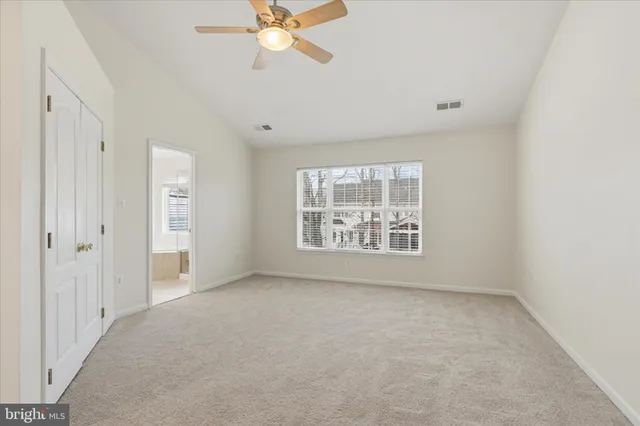 an empty room with windows and fan
