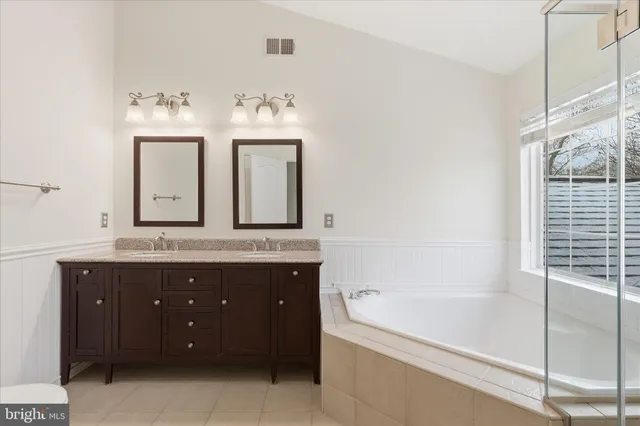a spacious bathroom with a granite countertop tub shower and sink