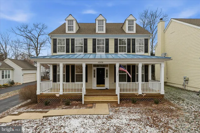 a view of a white house with large windows and a yard