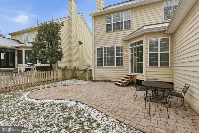 a backyard of a house with large tree and wooden fence