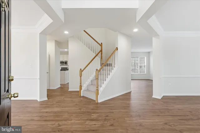 a view of entryway and hall with wooden floor