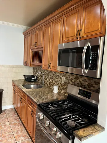 a kitchen with granite countertop a stove and a sink
