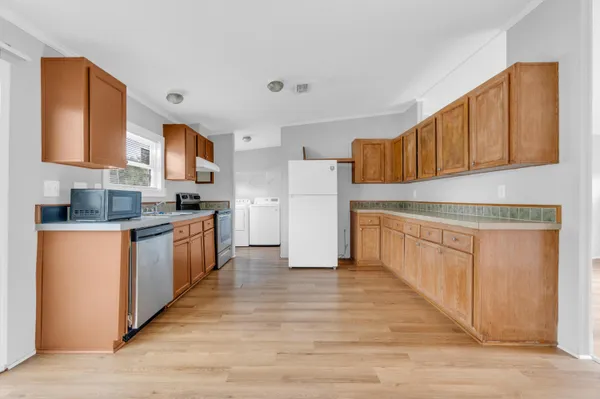 a kitchen with stainless steel appliances granite countertop a sink cabinets and wooden floor