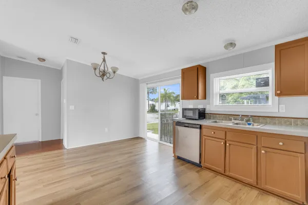 a kitchen with a refrigerator a stove top oven a sink and dishwasher with wooden floor