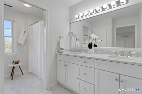 a bathroom with a double vanity sink a mirror and a