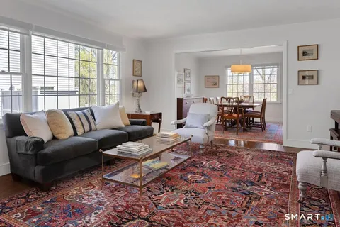 a living room with furniture wooden floor and a table