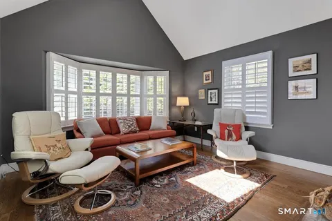 a living room with furniture a rug and a window