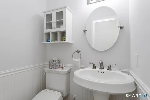 a bathroom with a toilet a sink and mirror