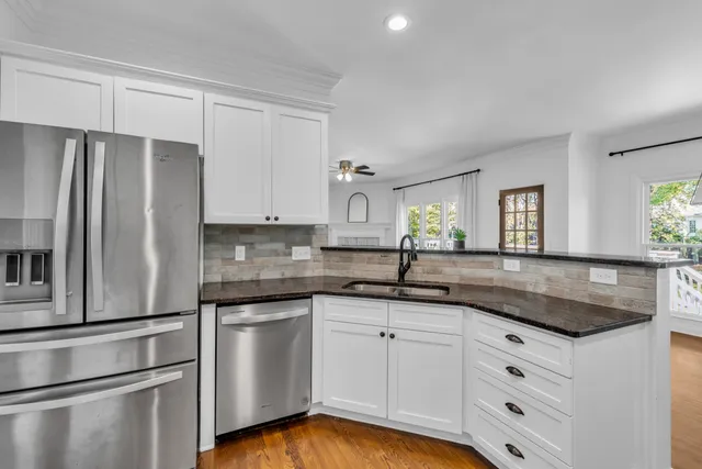 a kitchen with white cabinets white stainless steel appliances and sink