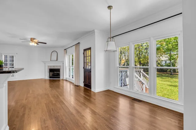 a view of an empty room with window and wooden floor
